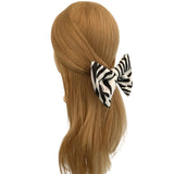 Zebra print hair clip on a mannequin head with brown hair against a white background