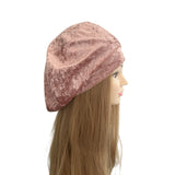 Pink velvet beanie on a mannequin head with long brown hair against a white background