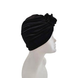 Black turban on a mannequin head against a white background