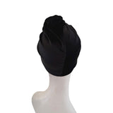Black turban on a mannequin head against a white background