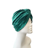 Green velvet turban on a mannequin head against a white background