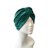 Green velvet turban on a mannequin head against a white background
