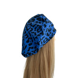 Blue leopard print headscarf on a mannequin head with blonde hair against a white background