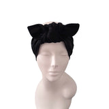 A black fabric headwrap turban hat with a large bow on top, displayed on a light gray mannequin head against a plain white background.