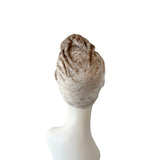 Beige headscarf on a mannequin head against a white background