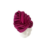 Magenta headscarf on a mannequin head against a white background