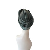 Green headscarf on a mannequin head against a white background