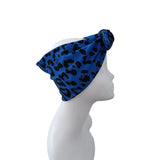 A blue and black leopard print headwrap turban hat displayed on a white mannequin head in profile against a solid white background.
