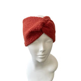 Red knitted headband on a mannequin head against a white background