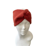 Red knitted headband on a mannequin head against a white background