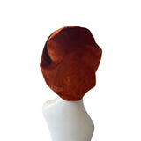 Brown headscarf on a white mannequin head against a white background
