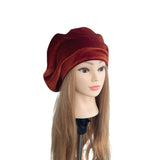 Mannequin head with long hair wearing a brown beret on a white background