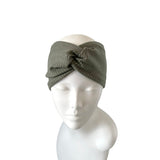 Green knotted headband on a mannequin head against a white background