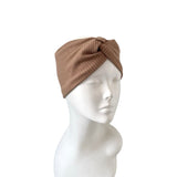 Brown knitted headband on a mannequin head against a white background