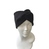 Black knit turban on a mannequin head against a white background