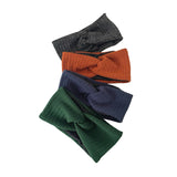 Four knitted headbands in black, orange, blue, and green on a white background