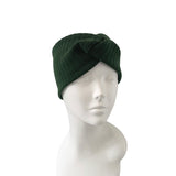 Green knitted turban on a mannequin head against a white background