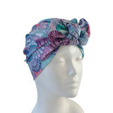 Colorful shell-patterned headscarf on a mannequin head against a white background