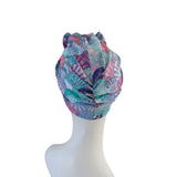 Colorful patterned headscarf on a mannequin head against a white background