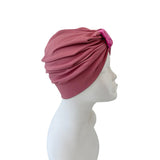 Pink headscarf on a mannequin head against a white background