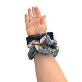 Hand wearing two colorful scrunchies on a white background ireland