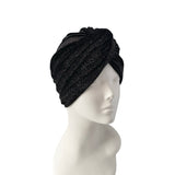 Black knit turban on a mannequin head against a white background