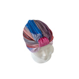Colorful striped turban on a mannequin head against a white background