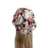 Multicolored shower cap on a mannequin head with blonde hair against a white background