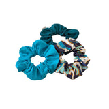 Three scrunchies in blue, green, and patterned design on a white background
