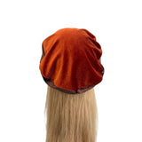 Brown beret on a mannequin head with blonde hair against a white background