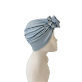 Light blue turban with a decorative bow on a mannequin head against a white background