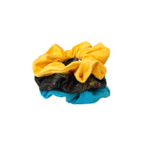 Three colorful scrunchies stacked on a white background