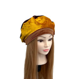 Mannequin head with a yellow and brown hat on a white background