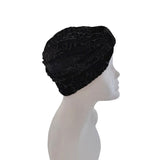 Black textured headscarf on a mannequin head against a white background