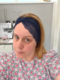Woman wearing a navy headband with a blurred background