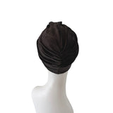 Black turban on a mannequin head against a white background