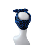 A blue and black leopard print headband tied in a bow on a white mannequin head, shown against a plain white background.