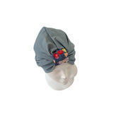 Gray headscarf with a colorful pattern on a mannequin head against a white background