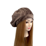 Brown patterned headscarf on a mannequin head with long brown hair against a white background