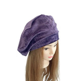 Purple velvet turban on a mannequin head with long brown hair against a white background