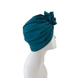 Teal headscarf on a mannequin head against a white background