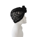 Black lace headscarf on a mannequin head against a white background