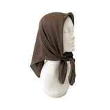 Brown headscarf on a mannequin head against a white background