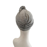 Gray turban on a mannequin head against a white background
