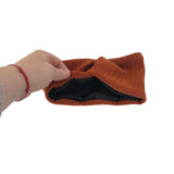 Brown knitted headband held by a hand on a white background
