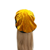 Yellow hooded towel on a mannequin head with blonde hair against a white background