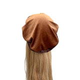 Brown hair cap on a mannequin head with blonde hair against a white background