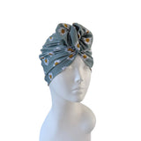 Gray headscarf with floral pattern on a mannequin head against a white background