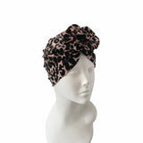 Leopard print headscarf on a mannequin head against a white background