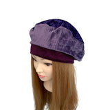 Purple velvet beret on a mannequin head with brown hair against a white background